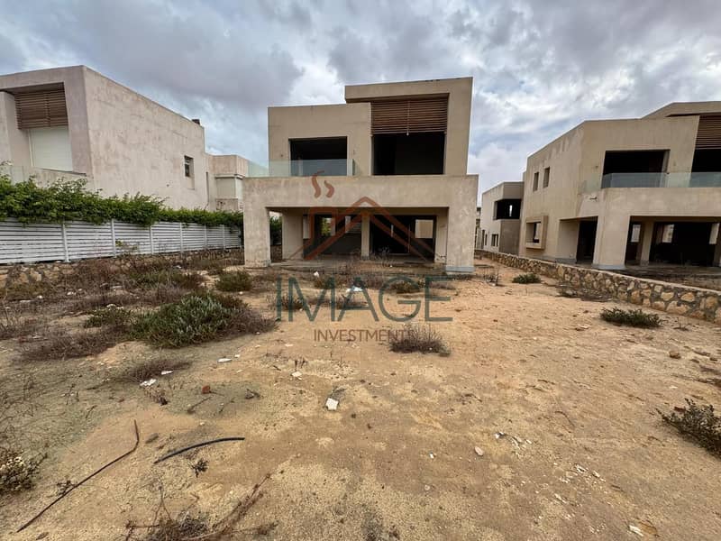 ڤيلا للبيع نصف تشطيب بأول صف جولف وبحيرة مع 4 غرف نوم وغرفة مربية وسائق داخل هاسيندا باي بالساحل الشمالي 0